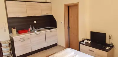 a small kitchen with a sink and a television at Summer Breeze Apartments in Sunny Beach
