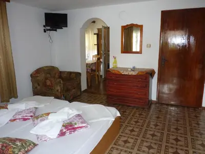 a bedroom with two beds and a dresser and a mirror at Guest House Zhelevi in Sozopol
