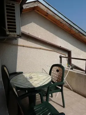 a patio table and chairs on a balcony at Milchevi Guesthouse in Sozopol