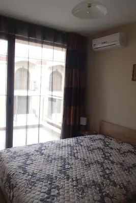 a bedroom with a bed and a large window at Sea'n'Pool Apartments in Hotel in Sozopol