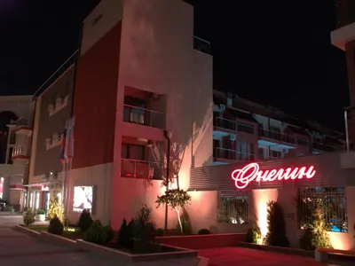 a building with a neon sign on it at night at Sea'n'Pool Apartments in Hotel in Sozopol