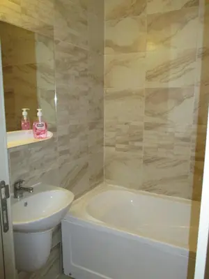 a bathroom with a sink and a tub and a toilet at Sea'n'Pool Apartments in Hotel in Sozopol