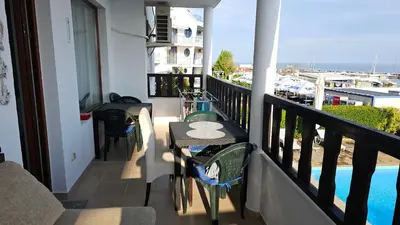 a balcony with a table and chairs and a pool at Complex Top Apartment in Sveti Vlas