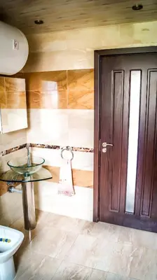 a bathroom with a sink and a wooden door at Guest House Meridi in Priseltsi