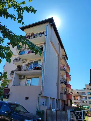 an apartment building with balconies and a car parked in front at Kovachevi House in Primorsko
