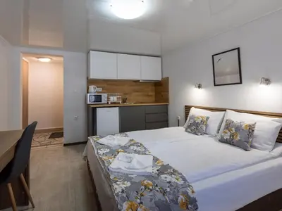 a bedroom with a large bed and a kitchen at Home Gramatikovi in Pomorie