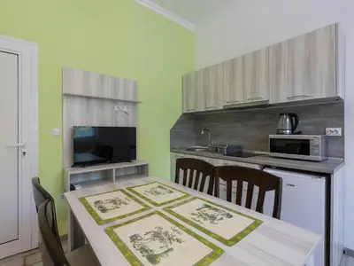 a kitchen with a table with chairs and a microwave at Home Gramatikovi in Pomorie