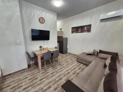 a living room with a couch and a table at Студио Лазур Поморие in Pomorie