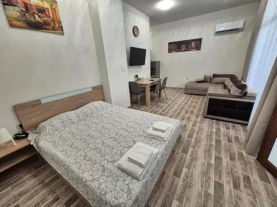 a living room with a bed and a couch at Студио Лазур Поморие in Pomorie