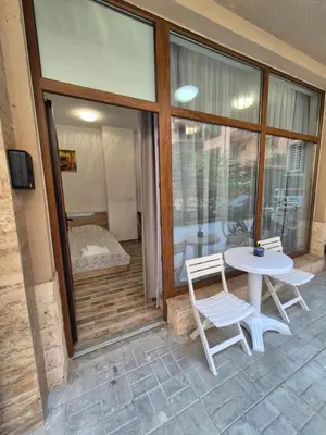 a patio with a table and two chairs and a window at Студио Лазур Поморие in Pomorie