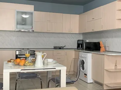 a kitchen with a table with a bowl of fruit on it at Бяла Виста Клиф - Byala Vista Cliff in Byala