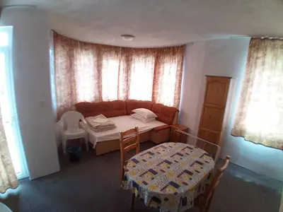 a room with a bed and a table and a window at Zlatevi Guest House in Obzor