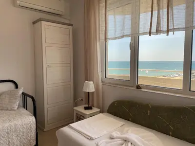 a bedroom with a bed and a view of the beach at Apartments Panorama Ravda in Ravda