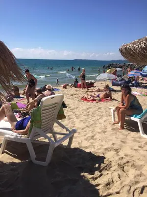 a group of people sitting in chairs on a beach at Siana 1 Apartment in Sveti Vlas