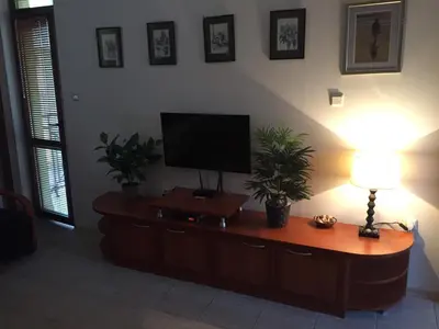a living room with a flat screen tv on a cabinet at Siana 1 Apartment in Sveti Vlas