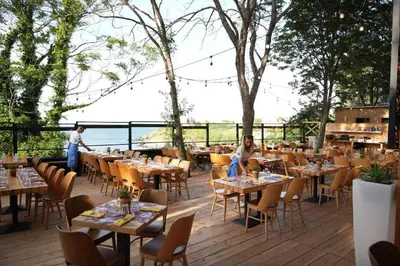 a restaurant with tables and chairs on a deck at Paradise Bay D8 Apartment in Sozopol