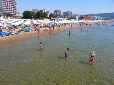 a group of people in the water at a beach at Menada Crystal Park Apartments in Sunny Beach