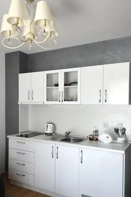 a kitchen with white cabinets and a sink at Stela Apartments in Obzor