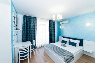 a bedroom with a bed and a table and a desk at Stela Apartments in Obzor