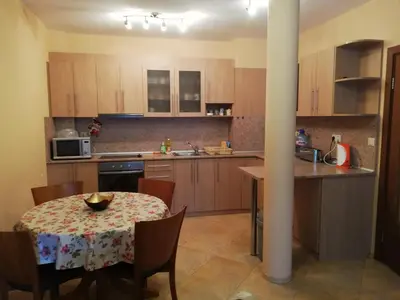 a kitchen with a table and chairs and a kitchen with a table and a table at Comfort Zamenhof in Varna City