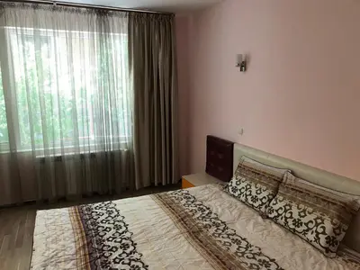 a bedroom with a bed and a large window at Jane Guest House in Nesebar