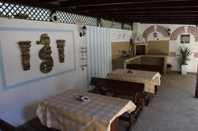 a restaurant with two tables and a kitchen at Jane Guest House in Nesebar