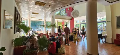 a group of people standing in a lobby with luggage at Hotel Shipka Beach in Sunny Beach