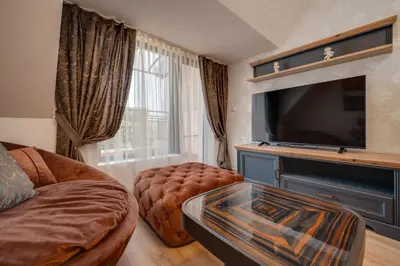 a living room with a couch and a tv at Prestige Central Apartments in Varna City