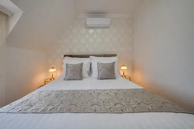 a bedroom with a large bed with two lamps at Prestige Central Apartments in Varna City