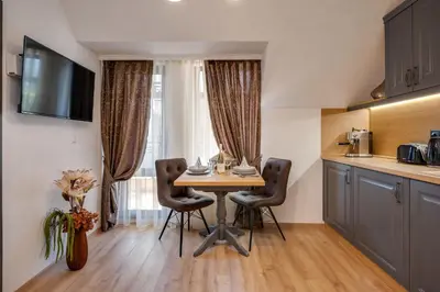 a kitchen with a table and chairs in a room at Prestige Central Apartments in Varna City