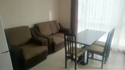 a living room with a couch and a table and a chair at Casa del Sol Apartments in Sunny Beach