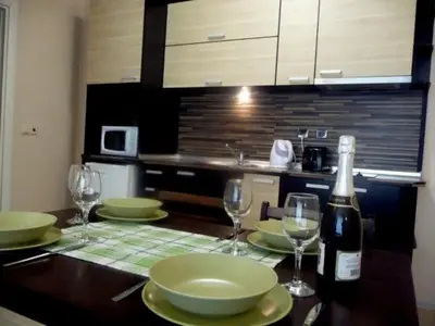 a kitchen with a table with glasses and a bottle of wine at Casa del Sol Apartments in Sunny Beach