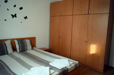 a bedroom with a bed with wooden cabinets and bats on the wall at Sea Garden in Burgas City
