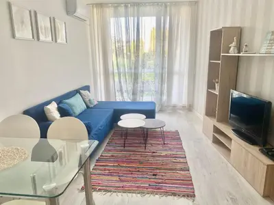 a living room with a blue couch and a table at Apartments in Sunny Island Complex in Chernomorets