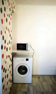a washing machine with a microwave on top of it at Flora Beach Apartaments in Burgas City
