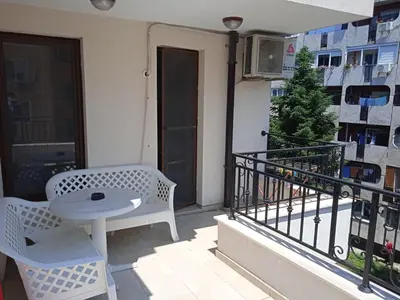a balcony with a table and chairs on a balcony at Flora Beach Apartaments in Burgas City