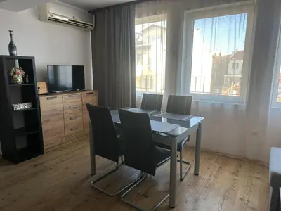 a dining room with a table and chairs and a television at Maisonette Sevastiyan in Varna City