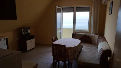 a living room with a couch and a table and a window at Villa Krisia Apartments in Sozopol
