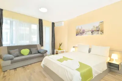 a bedroom with a large bed and a couch at Central studio 1 in Burgas City
