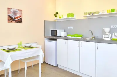 a kitchen with white cabinets and a table and a microwave at Central studio 1 in Burgas City