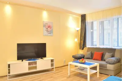 a living room with a couch and a flat screen tv at Central studio #2 in Burgas City