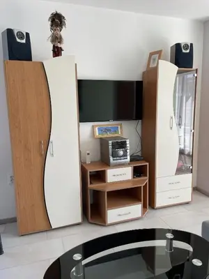 a living room with two white cabinets and a tv at Pearl Sunshine Appartments in Primorsko