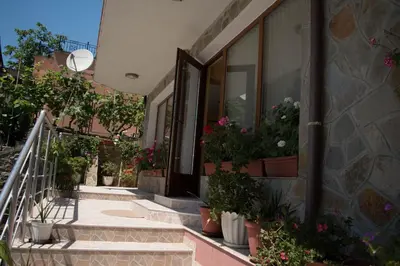 a building with potted plants on the side of it at Guest House Byki in Sveti Vlas