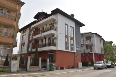 a building with cars parked in front of it at Guest House SG-BROTHERS in Obzor
