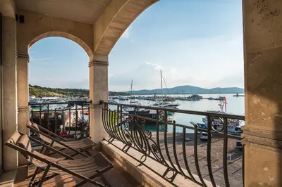 a balcony with chairs and a view of a marina at Blu Bay Hotel Sozopol in Sozopol
