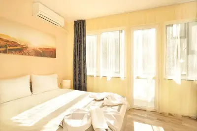 a bedroom with a white bed and windows at Central studio #3 in Burgas City