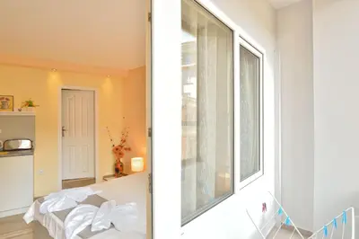 two views of a room with a window at Central studio #3 in Burgas City