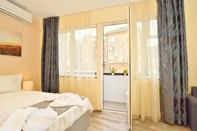 a bedroom with a bed and a large window at Central studio #3 in Burgas City