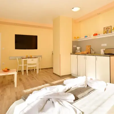 a room with a bed and a kitchen and a table at Central studio #3 in Burgas City