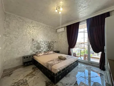 a bedroom with a bed and a large window at Dracena Guesthouse in Ravda